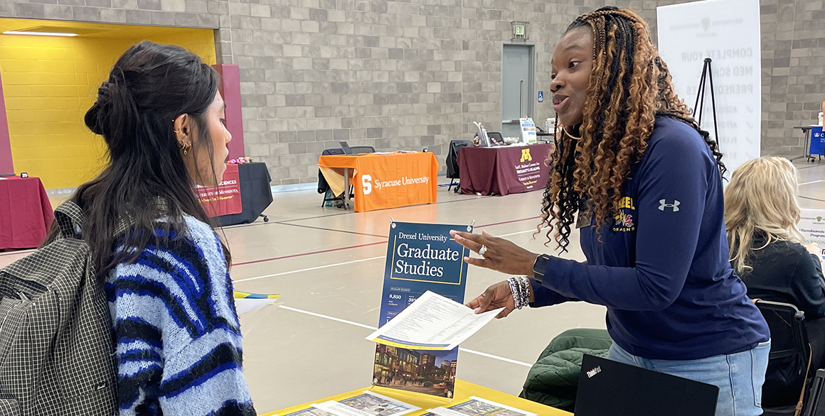 Student talking with a tabling representative at a career fair