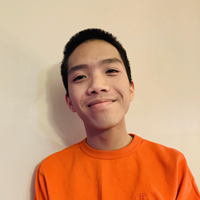 Ben wearing an orange shirt against a gray background