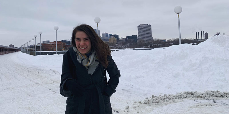 Alex Rich standing on the stone arch bridge in the winter