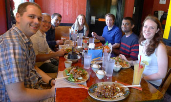 Members of the Seelig lab sitting at a table smiling