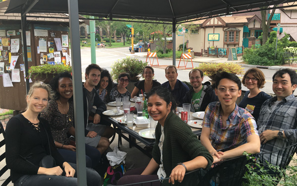 Members of the Seelig lab sitting at a table smiling