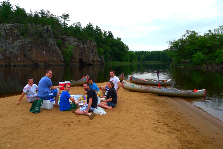 Seelig lab members with canoes on beach near river