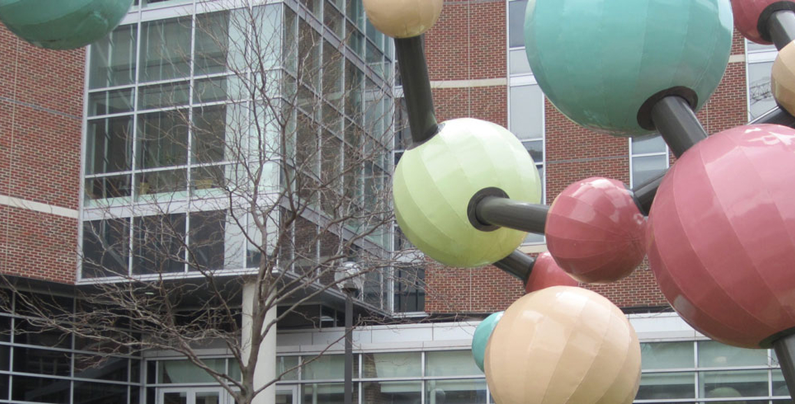 Molecule sculpture with brick building