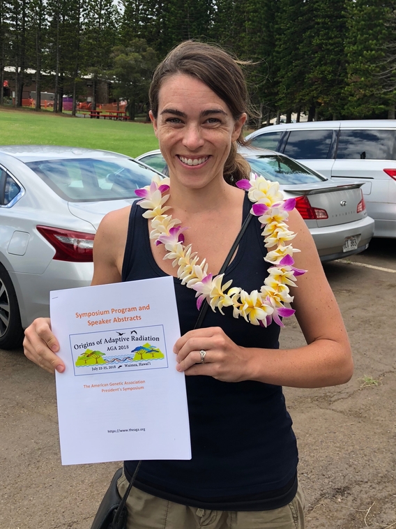 Justa Heinen-Kay holding a speaker abstract sign