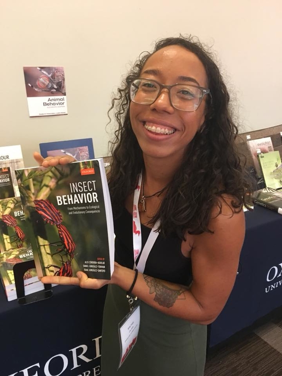 Rachel Olzer holding the book "Insect Behavior"