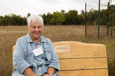 Judi Huempfner sitting on a bench at Cedar Creek. 